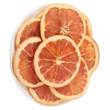 Αποξηραμένες φέτες γκρέιπφρουτ σε λευκό πιάτο, έτοιμες για διακόσμηση