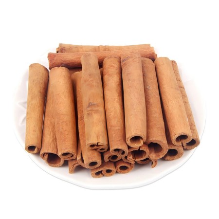 Αποξηραμένα στικ κανέλας σε λευκό πιάτο, έτοιμα για χρήση στη μαγειρική ή τη διακόσμηση.