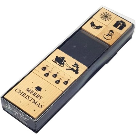 Σετ με 7 ξύλινες χριστουγεννιάτικες σφραγίδες και ένα μαύρο ταμπόν με μελάνι, σε ξύλινη επιφάνεια.